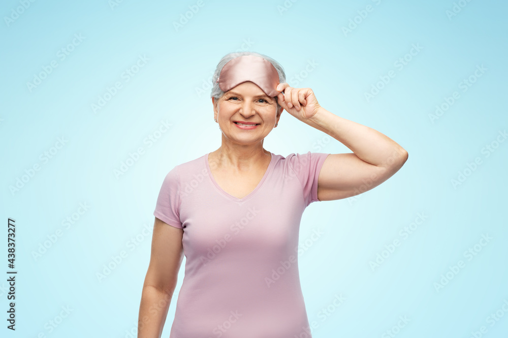 old people concept - portrait of smiling senior woman in pajamas and eye sleeping mask over blue background old people concept - portrait of smiling senior woman in pajamas and eye sleeping mask over blue background