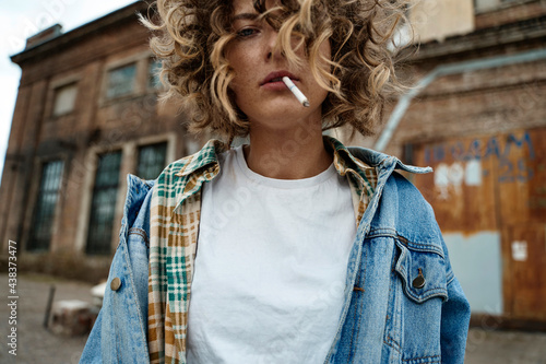 Stylish calm woman smoking in abandoned place