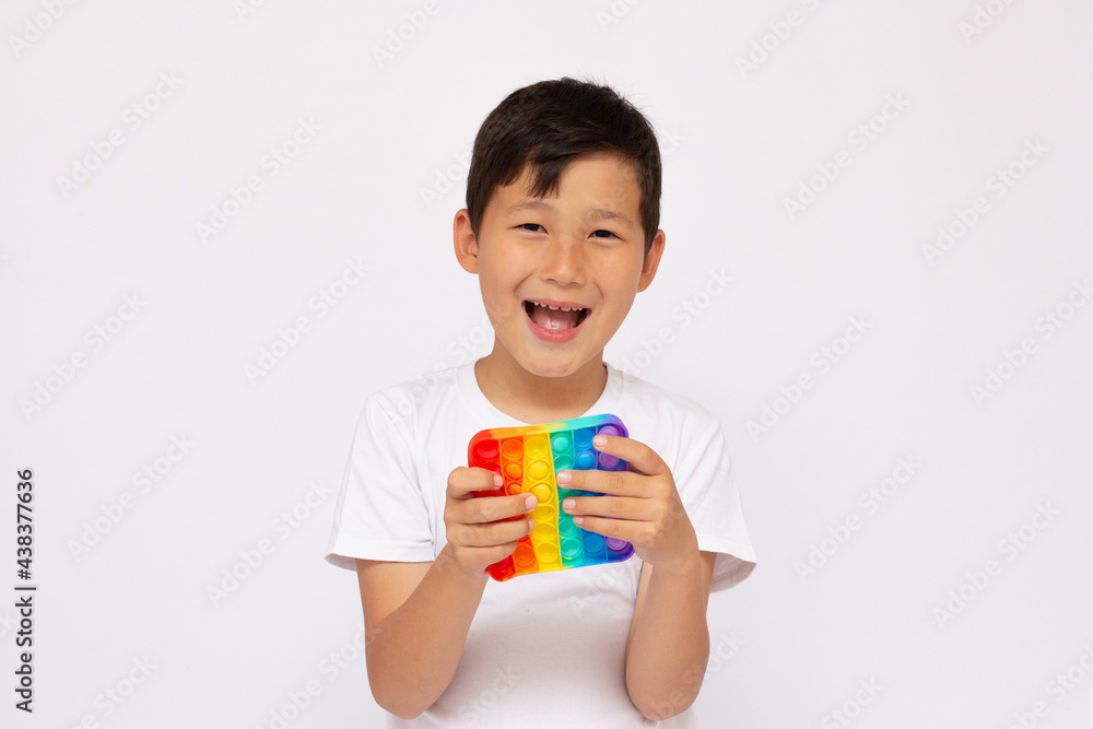 Child plays with sensory fidget toy Pop-it. Instrument for fine motoric skils, tool to start counting, learn primary arithmetic operations. A sedative for finger stimulation, relaxation.Happy face Child plays with sensory fidget toy Pop-it. Instrument for fine motoric skils, tool to start counting, learn primary arithmetic operations. A sedative for finger stimulation, relaxation.Happy face