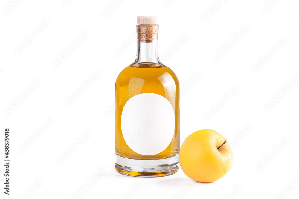 Fresh yellow apple and bottle with fruit brandy. Bottle with oval label, amber liquid and yellow apple isolated on white background. Homemade fruit alcohol concept. Fresh yellow apple and bottle with fruit brandy. Bottle with oval label, amber liquid and yellow apple isolated on white background. Homemade fruit alcohol concept.