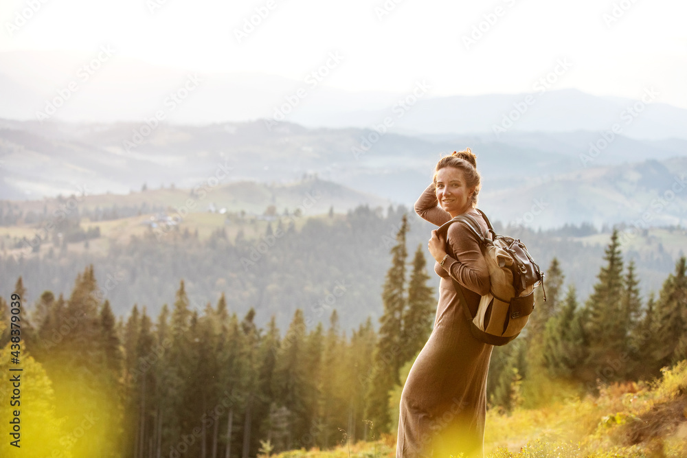 Woman hiker resting after climbing  at sunset