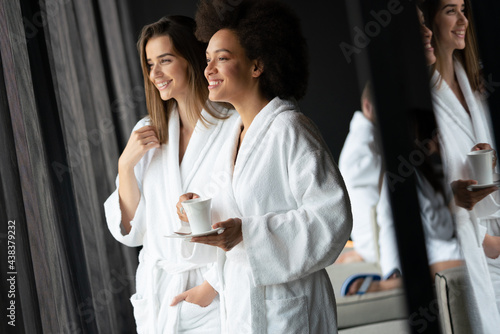 Portrait of happy cheerful girl in robe talking with her friend