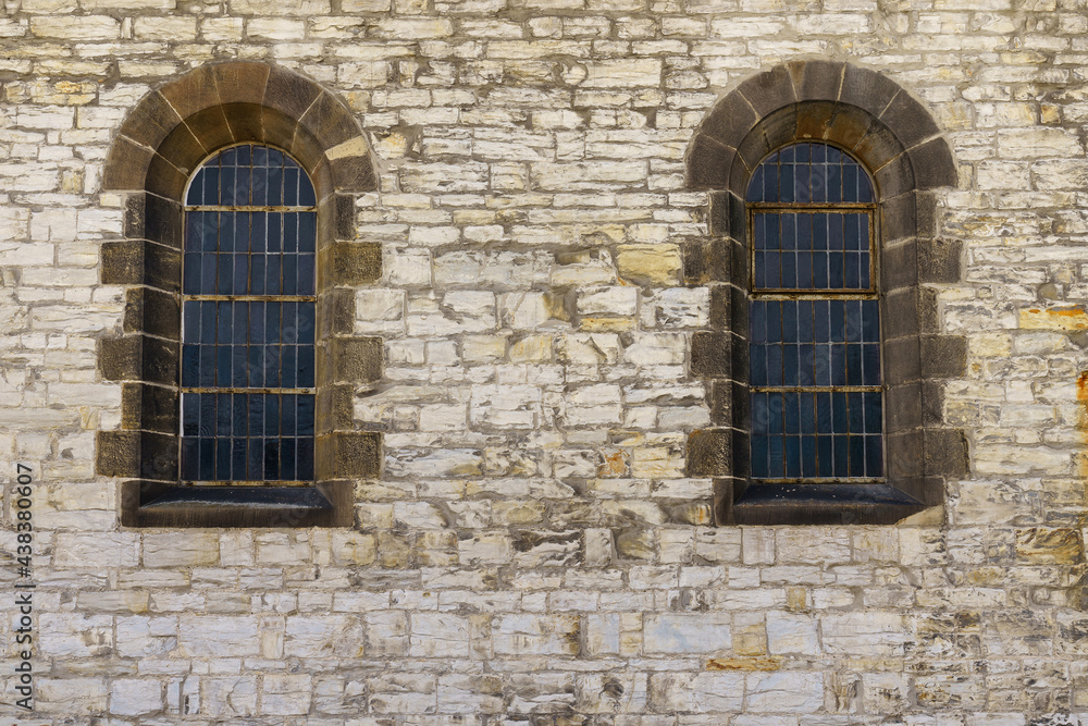Stone wall of the church with two windows with arches. Stone wall of the church with two windows with arches.