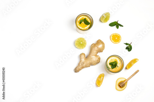 Tea, ginger root, honey, lemons slices and green fresh mint flat lay isolated on white background. Food balance and detox concept composition.