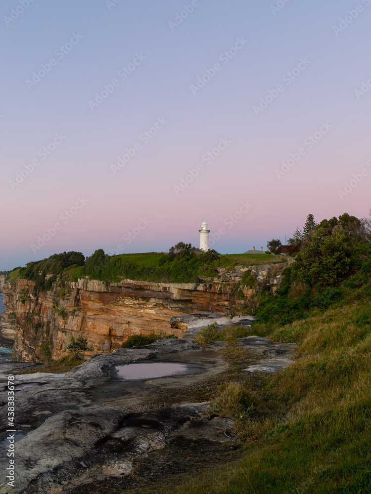 Sunrise view of Macquarie Lighthouse by the ocean, Sydney, Australia.