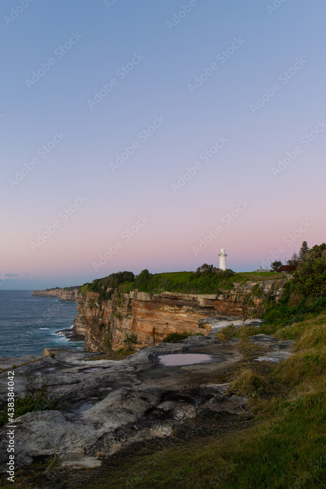 Sunrise view of Macquarie Lighthouse by the ocean, Sydney, Australia.
