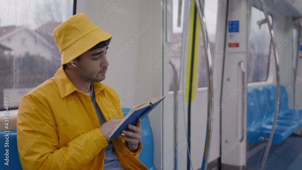 Handsome man reading book in subway car Handsome man reading book in subway car