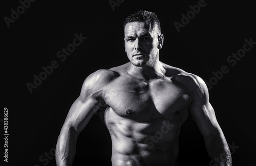 Strong athletic man showing muscular body and sixpack abs. Showing muscular torso. Black and white © Yevhen