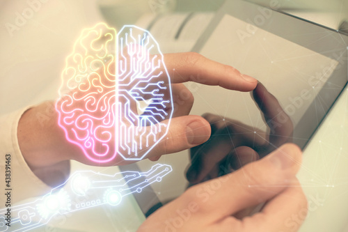 Double exposure of man's hand holding and using a digital device and brain hologram drawing. Data concept.