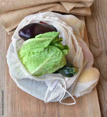 fresh vegetables in a reusable bag put on a wooden table ...