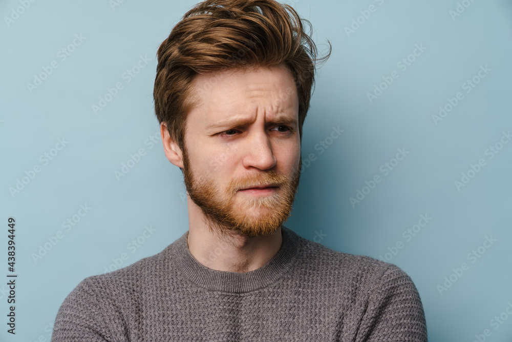 Fototapeta premium White ginger man with beard frowning and looking aside
