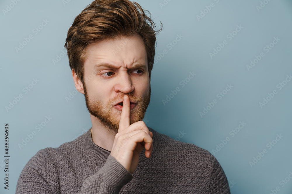 White ginger man with beard showing silence gesture at camera White ginger man with beard showing silence gesture at camera