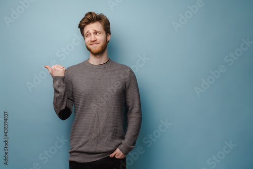White ginger man with beard frowning and pointing finger aside