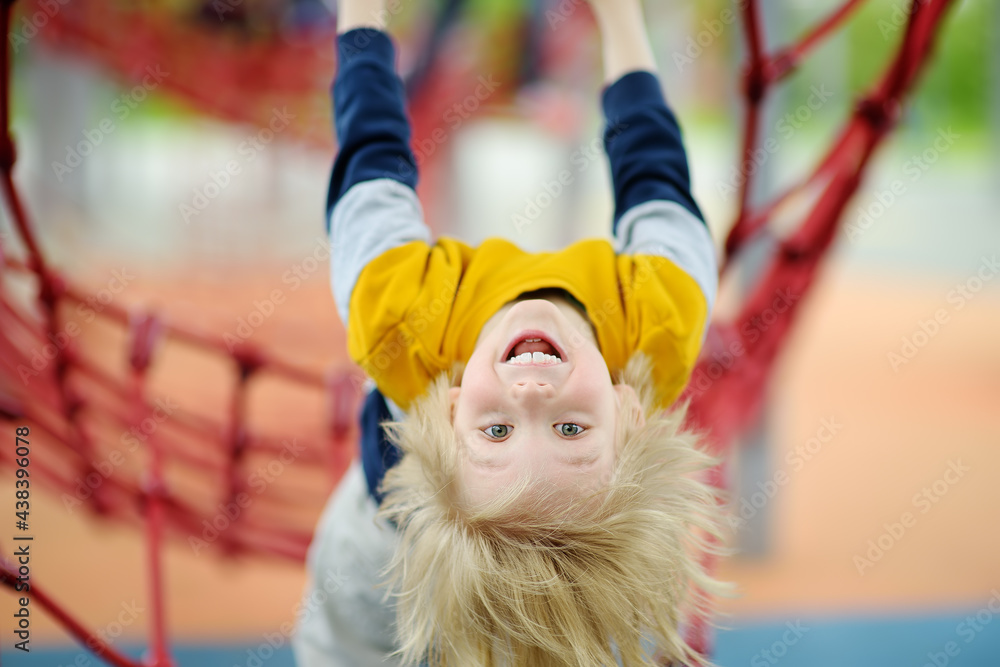 Сute perky preschooler boy having fun on outdoor playground. Spring/summer/autumn active sport leisure for kids. Outdoor activities for children. Сute perky preschooler boy having fun on outdoor playground. Spring/summer/autumn active sport leisure for kids. Outdoor activities for children.