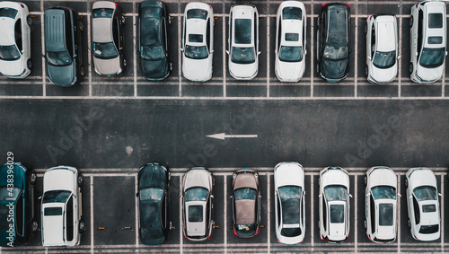 Fotografija Top down aerial view on payed parking lot with parked cars and one way direction road