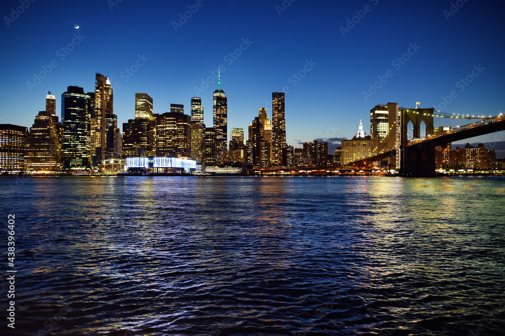 Obraz premium Skyscrapers of Manhattan and Brooklyn bridge at dusk. Famous bridge. Postcard view of New York. United States of America landmarks.