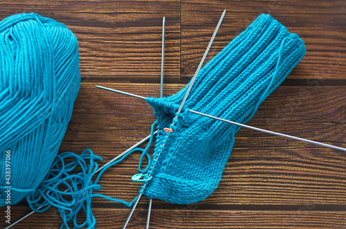 Knitting a warm sock from blue wool yarn