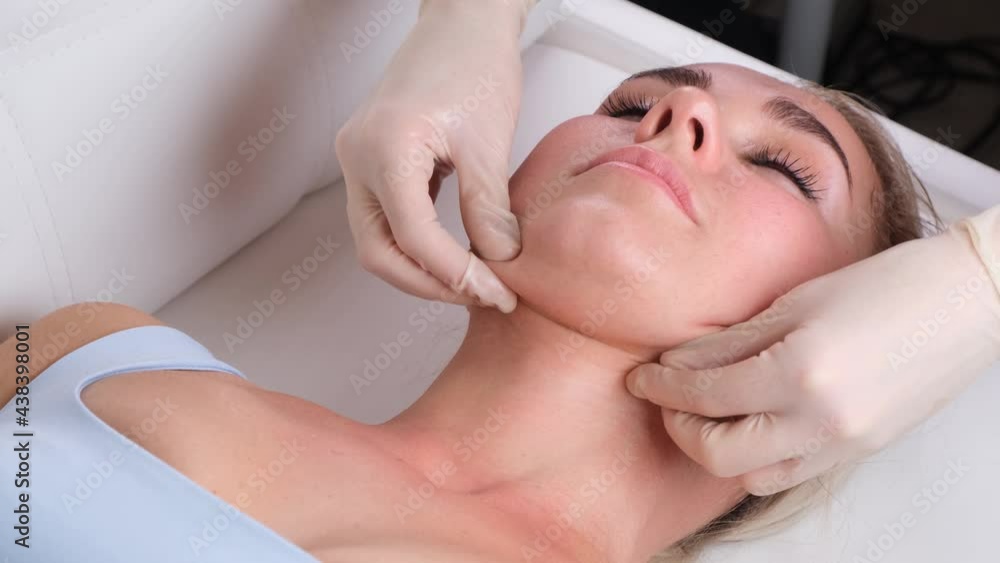 Chin massage of woman young woman during face massage at beauty salon Chin massage of woman young woman during face massage at beauty salon