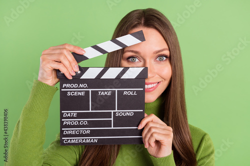 Photo of positive pretty young woman hold hands clapper smile hobby film isolated on green color background