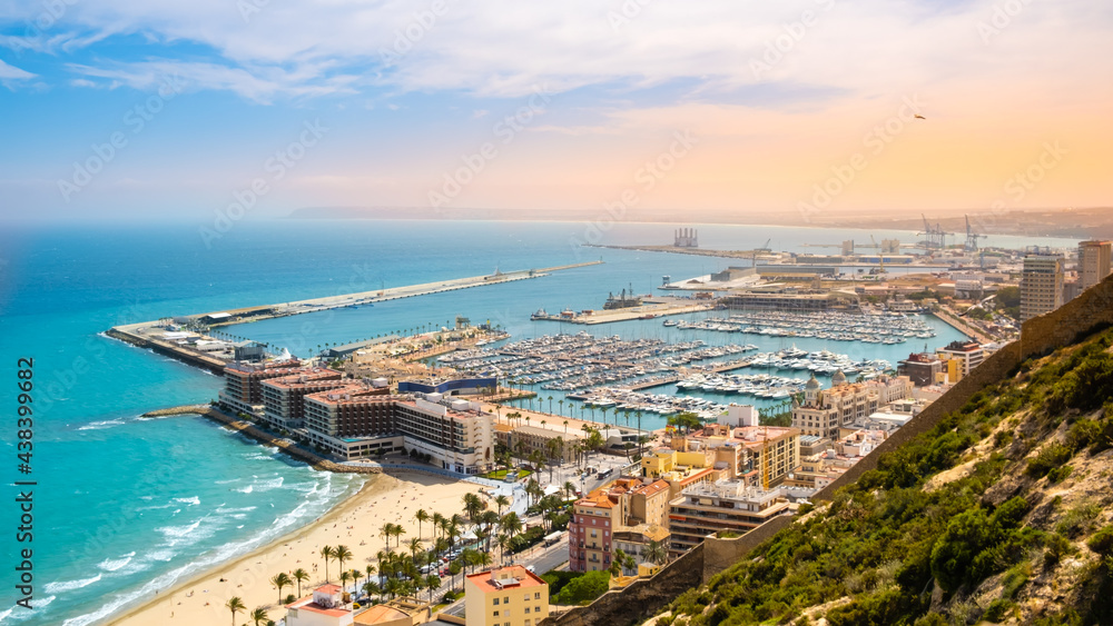Alicante, beach and port with luxury yachts and sailboats from above at sunset. View of beautiful touristic town in Costa Blanca region on Mediterranean sea coast, Spain