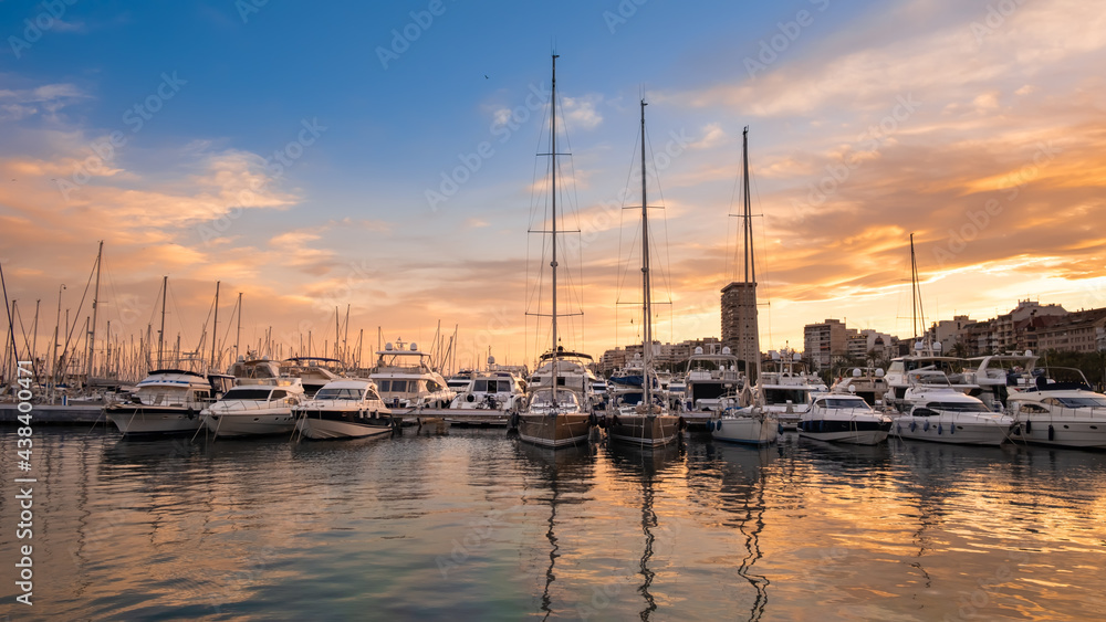 Alicante port with yachts and sailboats at sunset, Spain. Beautiful view of harbor in a touristic town in Costa Blanca region on Mediterranean sea coast