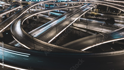 Night long exposure illumination of elevated multilevel traffic junction. Modern development of backlighted roads and current new infrastructure in China, Chengdu. Aerial drone point of view. © D. Kvasnetskyy