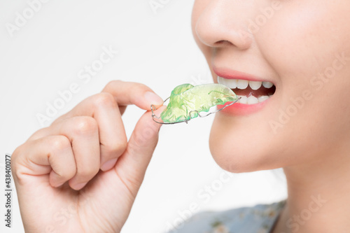 Asian woman holding orthodontic retainers.Teeth retaining tools after braces ...