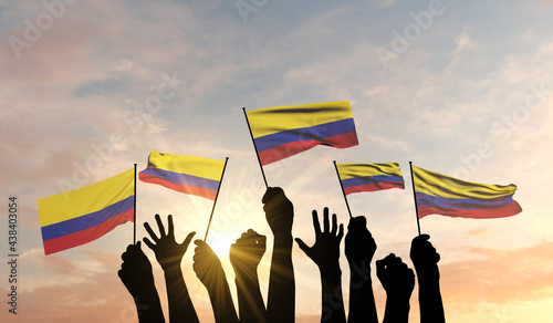Billede på lærred Silhouette of arms raised waving a Colombia flag with pride