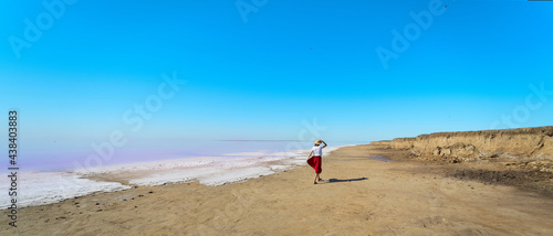 Panoramic image beautiful landscape, woman walking at beach near salt pink lake