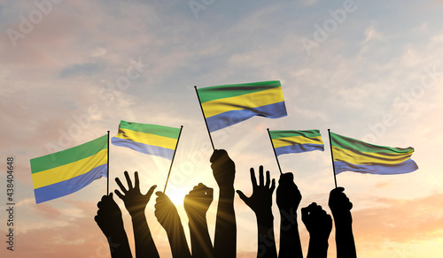 Silhouette of arms raised waving a Gabon flag with pride. 3D Rendering photo