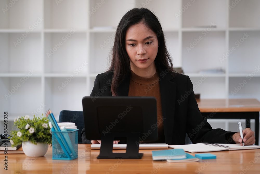 Closed up women holding pen and write something with keyboard and tablet on wooden table. Closed up women holding pen and write something with keyboard and tablet on wooden table.