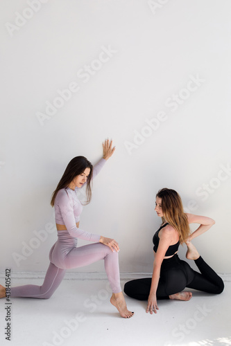 Two sports girls posing isolated on a white background. Fitness model woman in studio with copy space