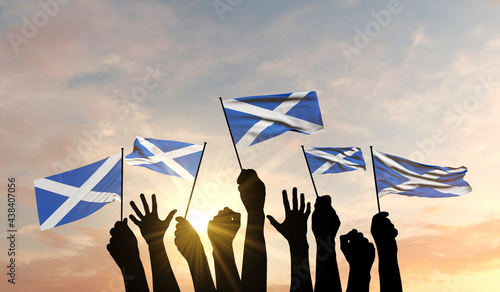 Silhouette of arms raised waving a Scotland flag with pride. 3D Rendering photo