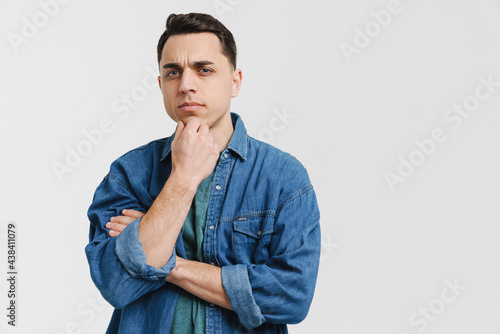 Young brunette white man frowning and looking at camera