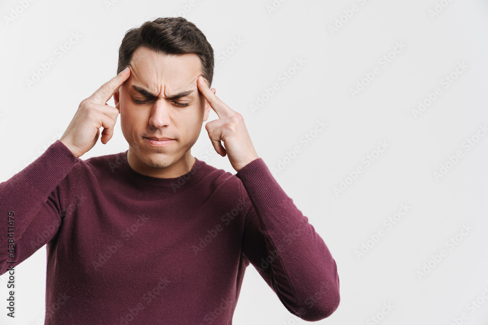 Young brunette man with headache rubbing his temples Young brunette man with headache rubbing his temples