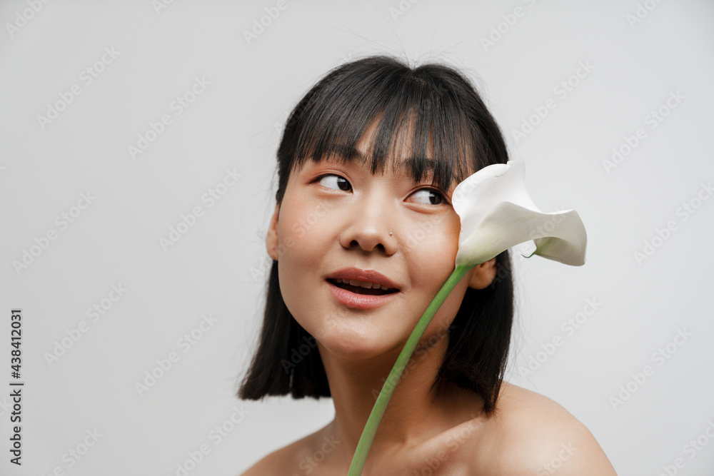 Young asian shirtless woman with piercing posing wit flower - obrazy, fototapety, plakaty 