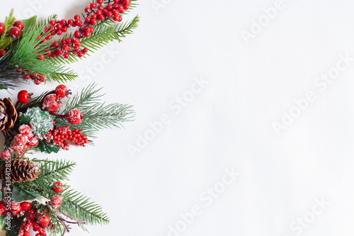 Card Christmas tree branches with red berries on a white background, copy space