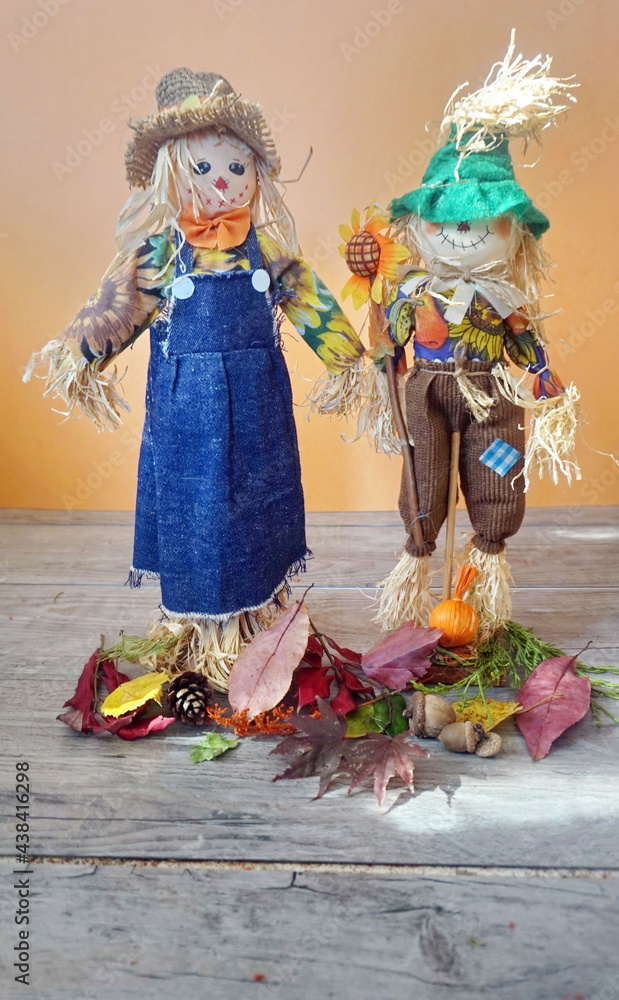 Folk Art Scarecrows on Wooden Panels with Orange Background in Daylight
