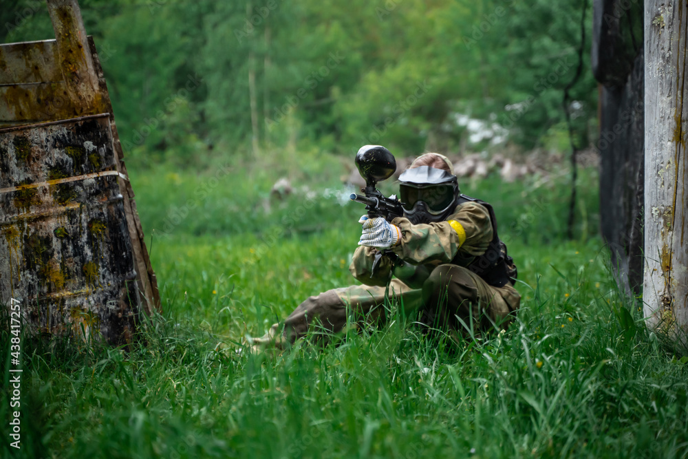 The player shoots a gun on the battlefield in a paintball The player shoots a gun on the battlefield in a paintball