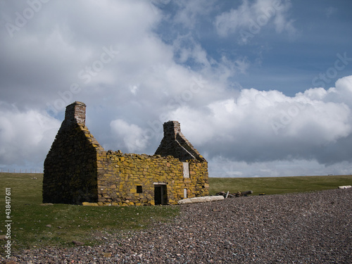 An abandoned, derelict croft or farm house on a pebble beach at Stenness, Northmavine in  Shetland, Scotland, UK