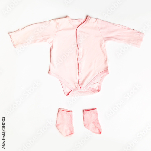 Flat lay composition with cute clothes for girl on white background. Baby accessories