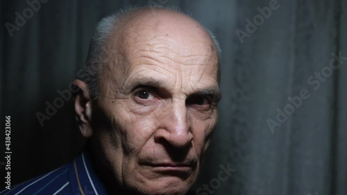 Large scale portrait of angry sullen aged man who turn about face standing at home in dark room