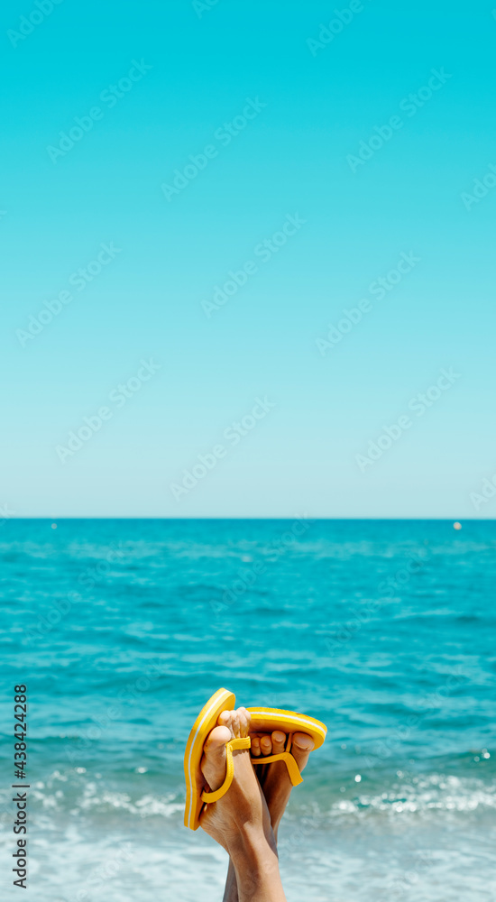 Obraz premium man wears flip-flops on the beach, mobile stories