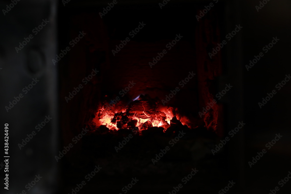 heated stove in the house with red coals and fire