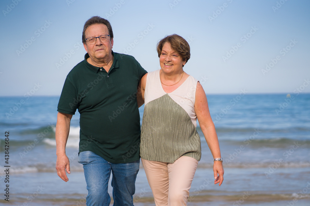 lifestyle portrait of loving happy and sweet mature couple - senior retired husband and wife on 70s enjoying beach walk relaxed and cheerful celebrating love together