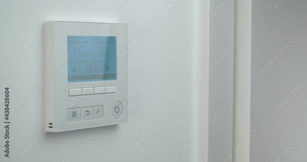 Woman hand changing temperature in remote controller of air conditioner to cold