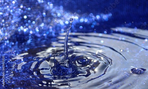 Wallpapers. Frozen movement of water. Drops of water falling and splashing. Sparkles, reflections of light. Intense blue color. 