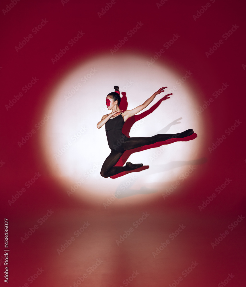 Ballet dancer dancing over red studio background. Modern design. Contemporary colorful conceptual light as rising sun at Japan. Ballet dancer dancing over red studio background. Modern design. Contemporary colorful conceptual light as rising sun at Japan.