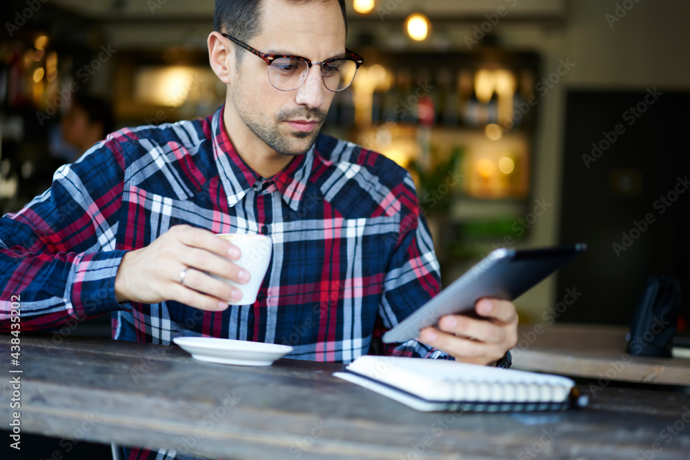 Pensive man using tablet with coffee Pensive man using tablet with coffee