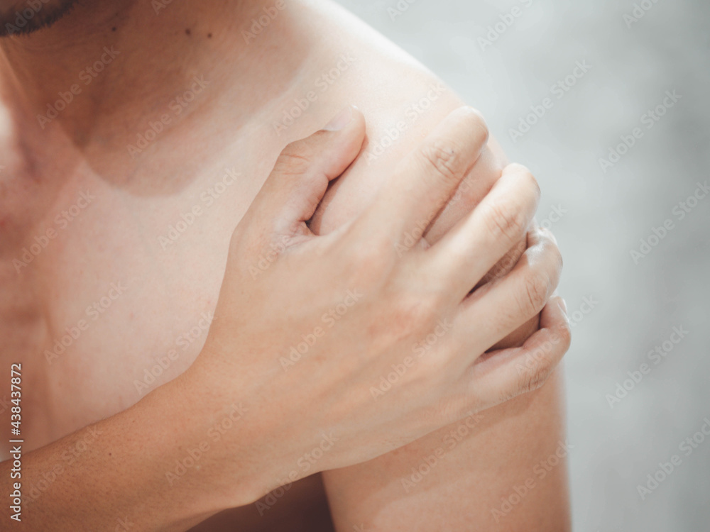 Naklejka premium A man suffering from pain in shoulder, closeup